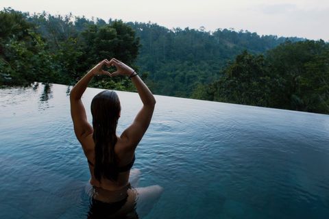 Woman Relaxing in Infinity Pool Surrounded by Tropical Nature