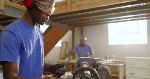 Craftsmen precision woodworking with lathe in artisan workshop
