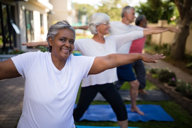 Senior individuals participating in an outdoor yoga session, promoting fitness and healthy lifestyle. Ideal for use in health and wellness campaigns, senior fitness programs, community activities, and advertisements focusing on active aging.