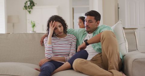 Stressed Parents Relaxing on Sofa in Cozy Home