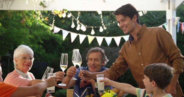 Joyful Family Toasting with Champagne in Sunny Garden - Download Free Stock Images Pikwizard.com