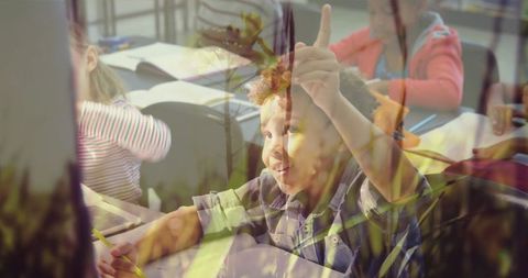 Eager young student raising hand in classroom