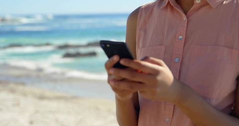 Woman Enjoying Leisure at Beach on Smartphone