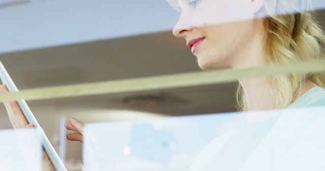 Woman smiling watching her tablet at restaurant 