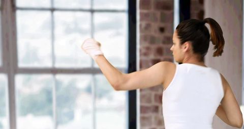 Energetic Woman Boxing in Modern Gym Interior