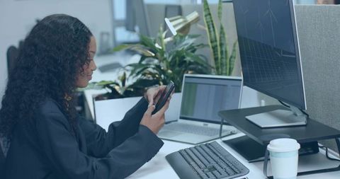 Businesswoman Engaging with Smartphone in Office Environment