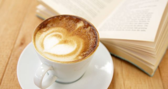 Latte with heart pattern and open book on wooden table - Download Free Stock Images Pikwizard.com