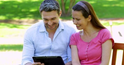 Smiling Couple on Park Bench Using Tablet Outdoors - Download Free Stock Images Pikwizard.com