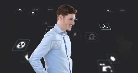 Businessman standing with holographic renewable energy icons on virtual interface corporate tech