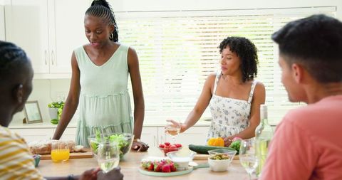 Friends Laughing and Cooking Together in Bright Modern Kitchen