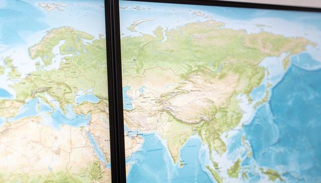 Displaying wall-mounted world map across two panels with visible seam and detailed relief