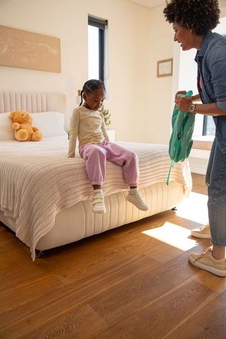 Mother and Daughter Preparing for Outing in Comfortable Bedroom