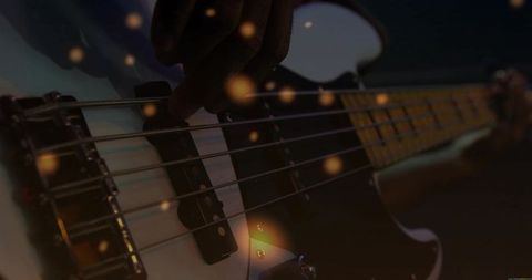 Musician Playing Bass Guitar Strings with Magical Bokeh Effect