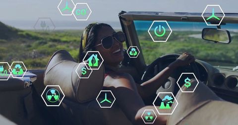 Smiling Woman in Convertible with Eco Icons by Scenic Coastline