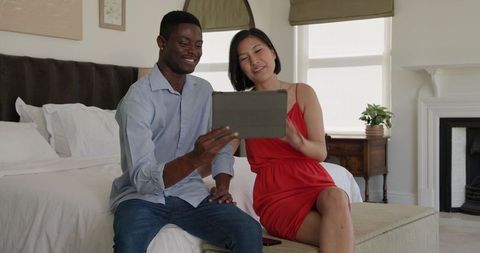 Diverse Couple Enjoying Tablet Technology at Home