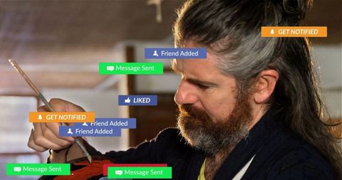 Craftsman painting wooden instrument amidst social media notifications