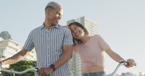 Joyful Diverse Couple Cycling on Seafront Promenade