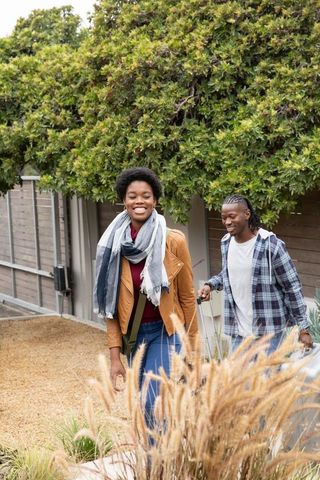 Couple Strolling with Luggage in Scenic Outdoor Setting