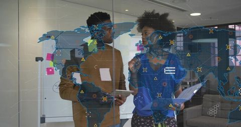 Collaborating over global data map discussing analytics strategy with tablet and reports