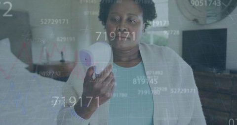 Senior woman checking temperature amid numeric overlay illustrations