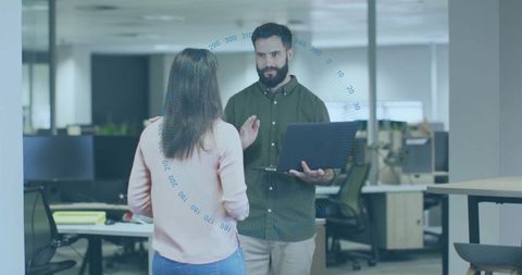 Two coworkers discussing project in modern office environment