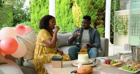Mature Couple Celebrating Anniversary with Cake and Champage on Patio