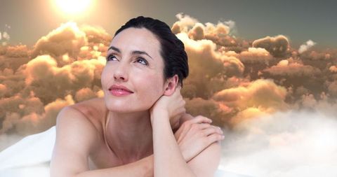 Woman Dreamily Gazing with Sunlit Cloudscape Background