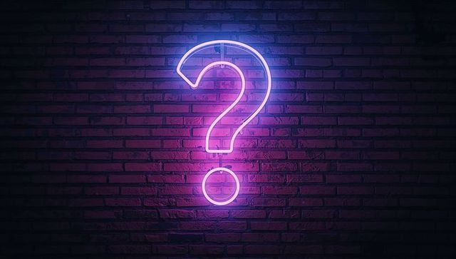 Neon Question Mark Illuminating Red Brick Wall Interior