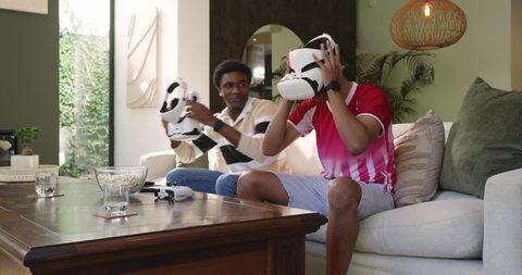 Two friends relaxing with virtual reality headsets at home