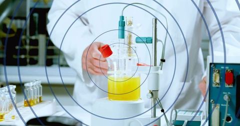 Adjusting lab reactor with yellow solution on magnetic stirrer, holding red cap, chemistry