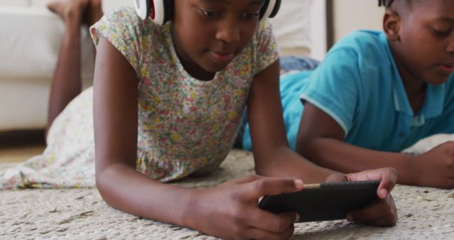 Children Relaxing at Home with Headphones and a Tablet - Download Free Stock Images Pikwizard.com