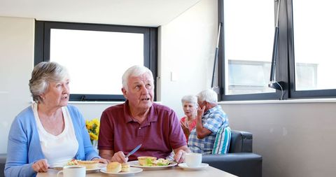 Senior Couple Enjoying Breakfast Conversation in Home Kitchen