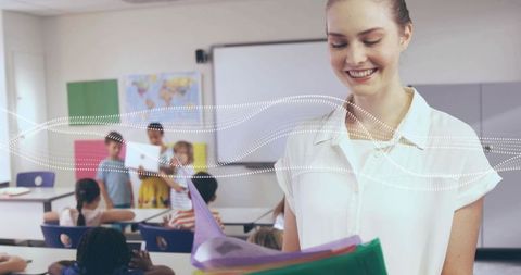 Smiling female teacher holding colorful folders leading elementary classroom activities