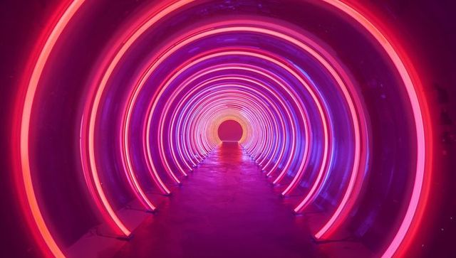Vibrant neon-lit tunnel arches with reflective floor