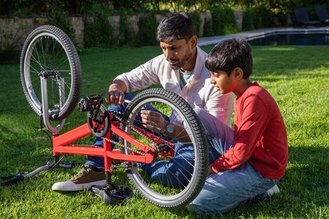 Father and Son Repairing Bicycle in Backyard