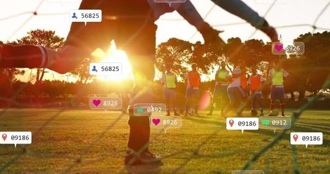 Goalkeeper making diving save on sports field at sunset