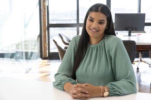 Smiling Businesswoman in Modern Office Near Conference Table