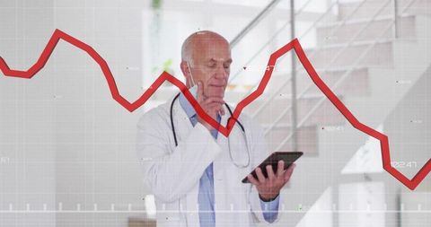 Senior Doctor Analyzing Data on Tablet with Declining Graph