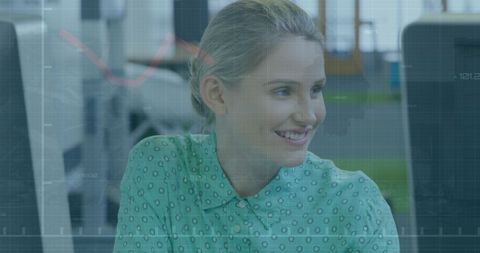 Smiling Businesswoman Reviewing Financial Data in Modern Office