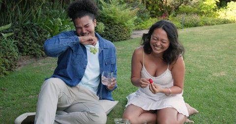 Couple Enjoying Laughter and Picnic Outdoors in Garden