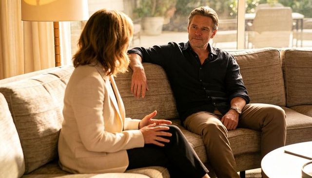 Couple talking on beige sofa in sunlit modern living room, casual conversation at home