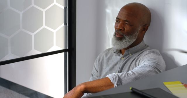 Thoughtful Senior Man Sitting in Modern Office Space - Download Free Stock Images Pikwizard.com