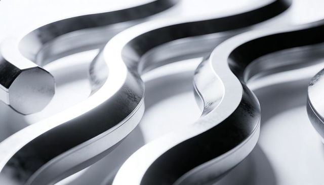 Polished wavy metal strips reflecting on white surface with hexagonal bar end