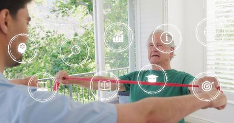 Senior man rehabilitating with resistance band therapist guiding in sunlit room with greenery