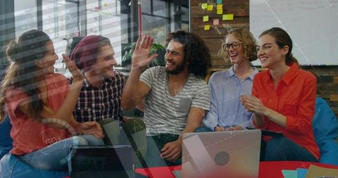 Startup team celebrating breakthrough: professionals collaborating in modern open plan office