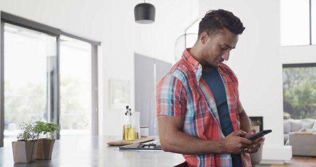 Young Man Checking Smartphone in Modern Kitchen - Download Free Stock Images Pikwizard.com