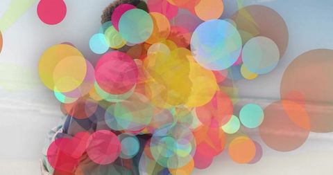 Mother and Son Laughing Amidst Bubbles at Serene Beach