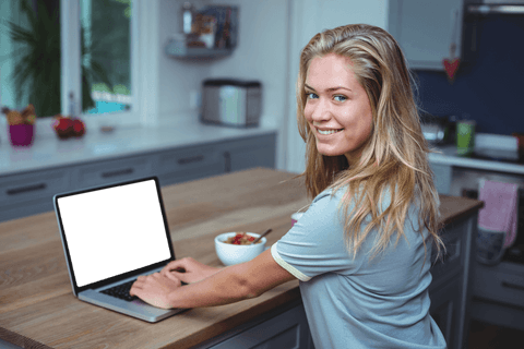 Smiling Woman Using Laptop in Bright Kitchen with Transparent Screen