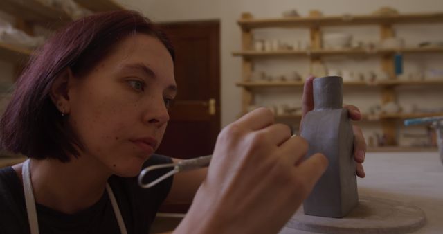 Woman concentrating while shaping clay in pottery studio - Download Free Stock Images Pikwizard.com