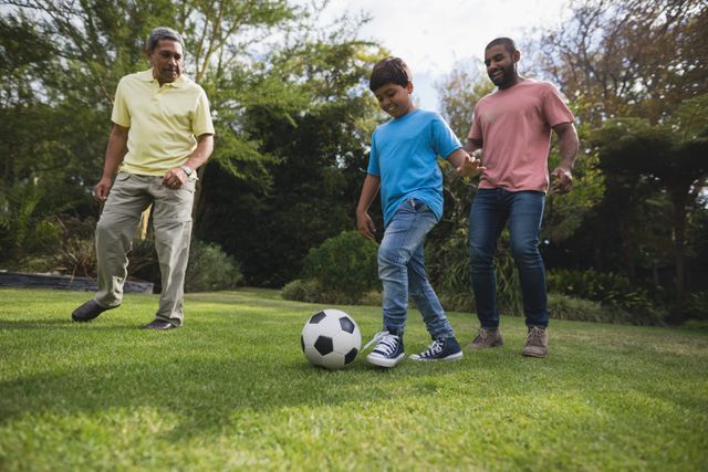 Multi-generation family enjoying time together playing soccer outdoors on a sunny day. Perfect for promoting family bonding, outdoor activities, fitness, and sports. Ideal for use in advertisements for parks, recreational activities, family services, and sports events.